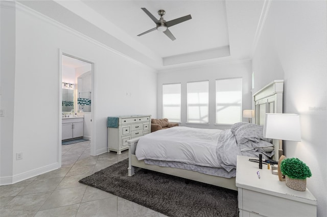 tiled bedroom featuring ceiling fan, ornamental molding, ensuite bathroom, and a tray ceiling