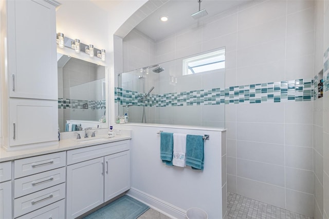 bathroom with tiled shower, vanity, and tile patterned floors