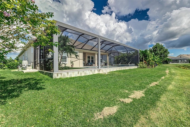 rear view of house with a lanai and a yard