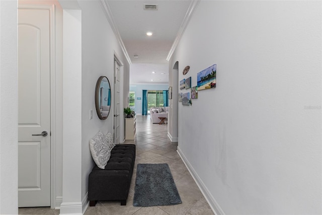 hall featuring crown molding and light tile patterned floors