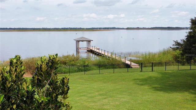 dock area with a water view and a yard