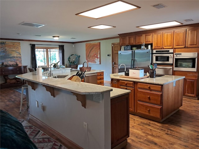 kitchen with a breakfast bar, a spacious island, stainless steel appliances, and crown molding