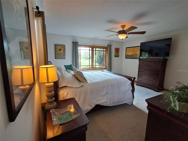 carpeted bedroom with ceiling fan and a textured ceiling