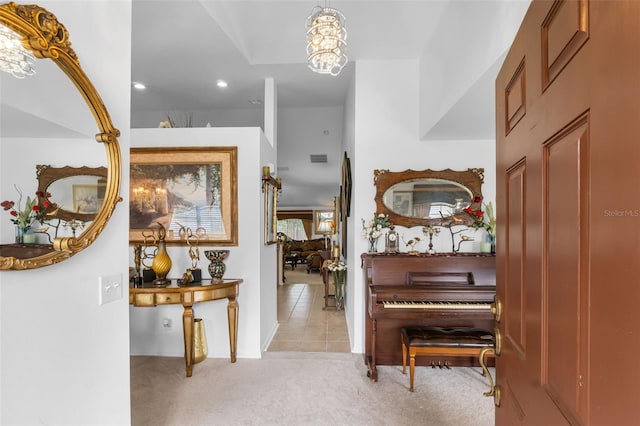 hall with a chandelier and light carpet