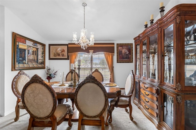 dining space featuring lofted ceiling, a chandelier, and carpet floors