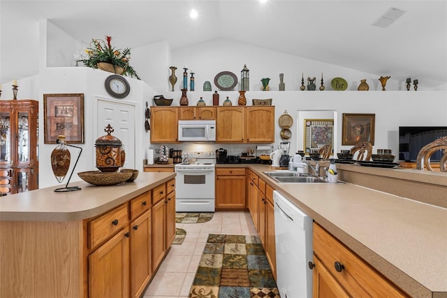 kitchen with vaulted ceiling, white appliances, a kitchen island, and sink