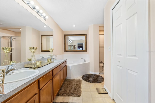 bathroom with tile patterned floors, shower with separate bathtub, and vanity