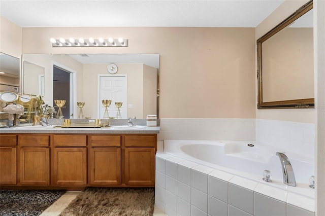 bathroom featuring vanity and tiled tub