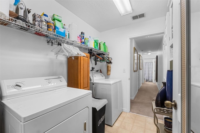 washroom with a textured ceiling and independent washer and dryer