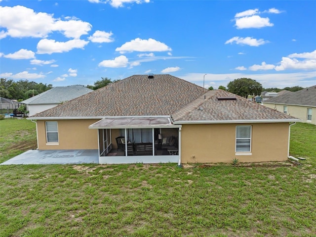 back of property with a lawn, a patio, and a sunroom