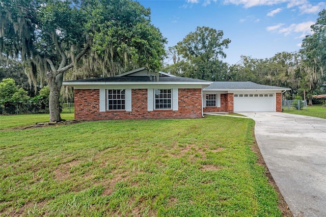 ranch-style home with driveway, brick siding, a garage, and a front lawn