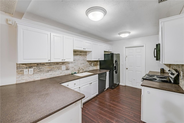 kitchen featuring a sink, dark countertops, dark wood-style floors, white cabinets, and black appliances