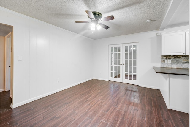 unfurnished living room with french doors, dark wood-style flooring, baseboards, a textured ceiling, and ceiling fan