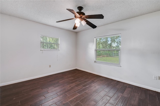 unfurnished room featuring baseboards, ceiling fan, dark wood-type flooring, and a textured ceiling