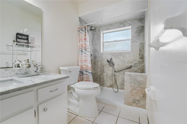 bathroom featuring a tile shower, toilet, tile patterned flooring, and vanity