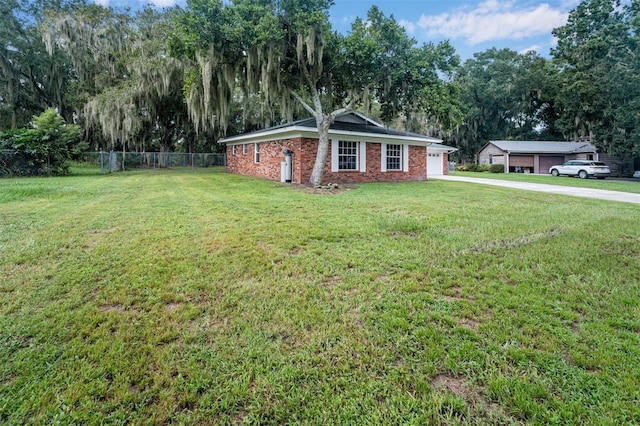 exterior space with brick siding, a front yard, driveway, and fence