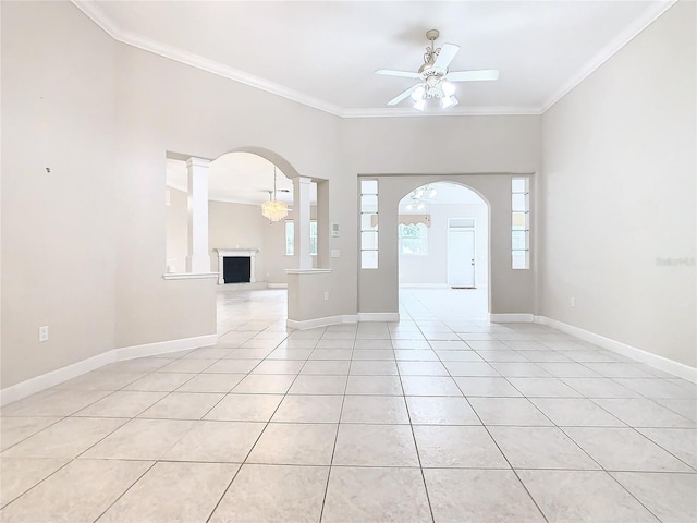 foyer featuring arched walkways, light tile patterned floors, ornate columns, and ornamental molding