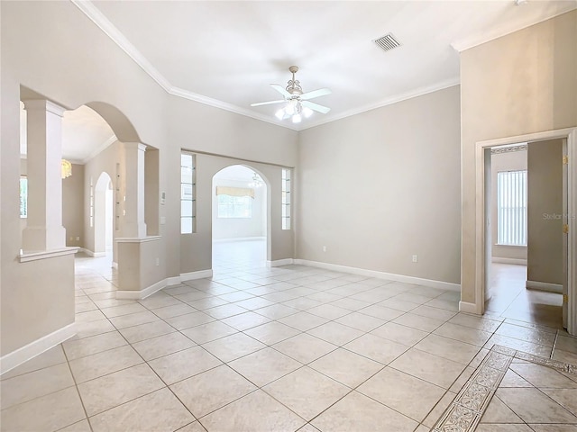 unfurnished room with crown molding, a ceiling fan, visible vents, and baseboards