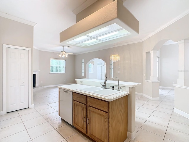 kitchen with open floor plan, arched walkways, white dishwasher, and a sink