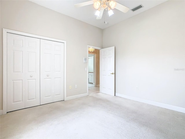 unfurnished bedroom with baseboards, visible vents, a closet, and light carpet