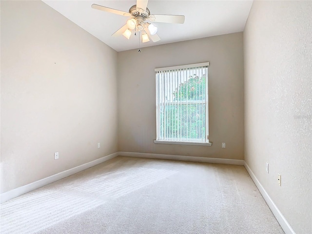 unfurnished room featuring baseboards, light colored carpet, and ceiling fan