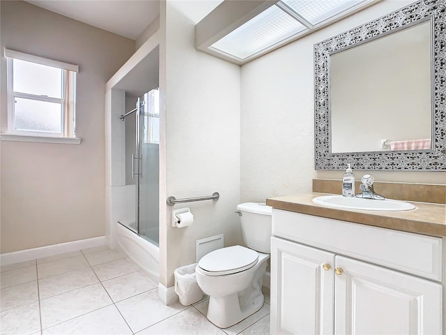 full bath featuring vanity, baseboards, bath / shower combo with glass door, tile patterned flooring, and toilet