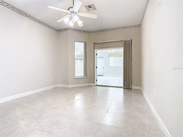 empty room with light tile patterned floors, visible vents, baseboards, and a ceiling fan