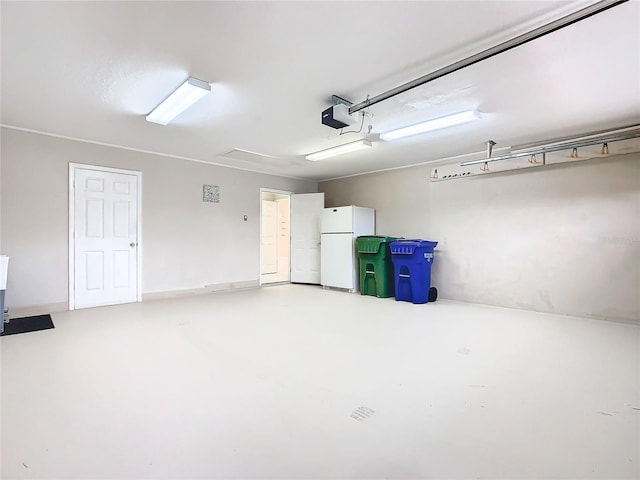 garage featuring a garage door opener and freestanding refrigerator