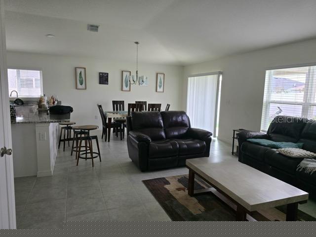 living room featuring plenty of natural light and a notable chandelier