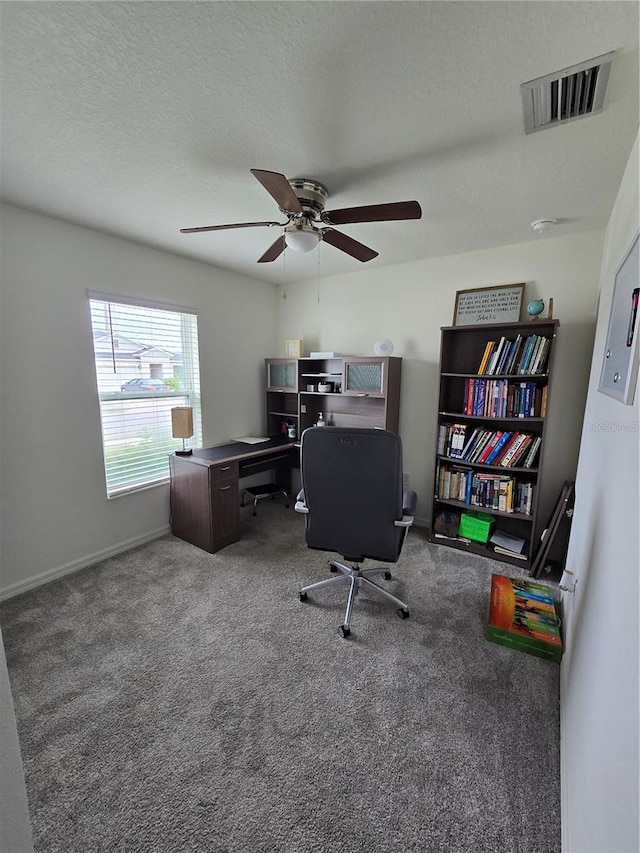 office with a textured ceiling, ceiling fan, and carpet