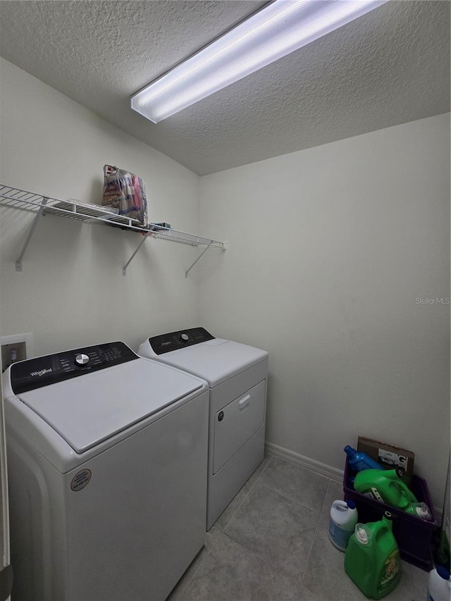 washroom featuring washing machine and clothes dryer and a textured ceiling