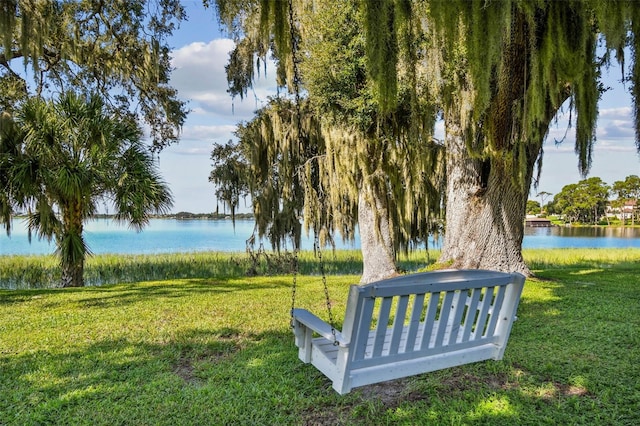 surrounding community with a yard and a water view