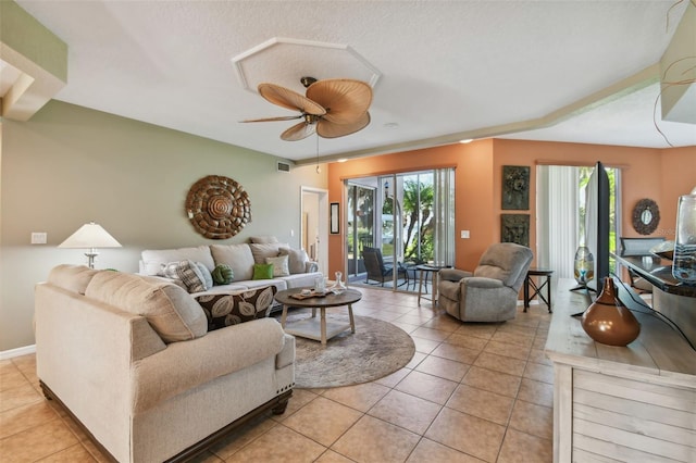 living room with ceiling fan, light tile patterned flooring, and a healthy amount of sunlight