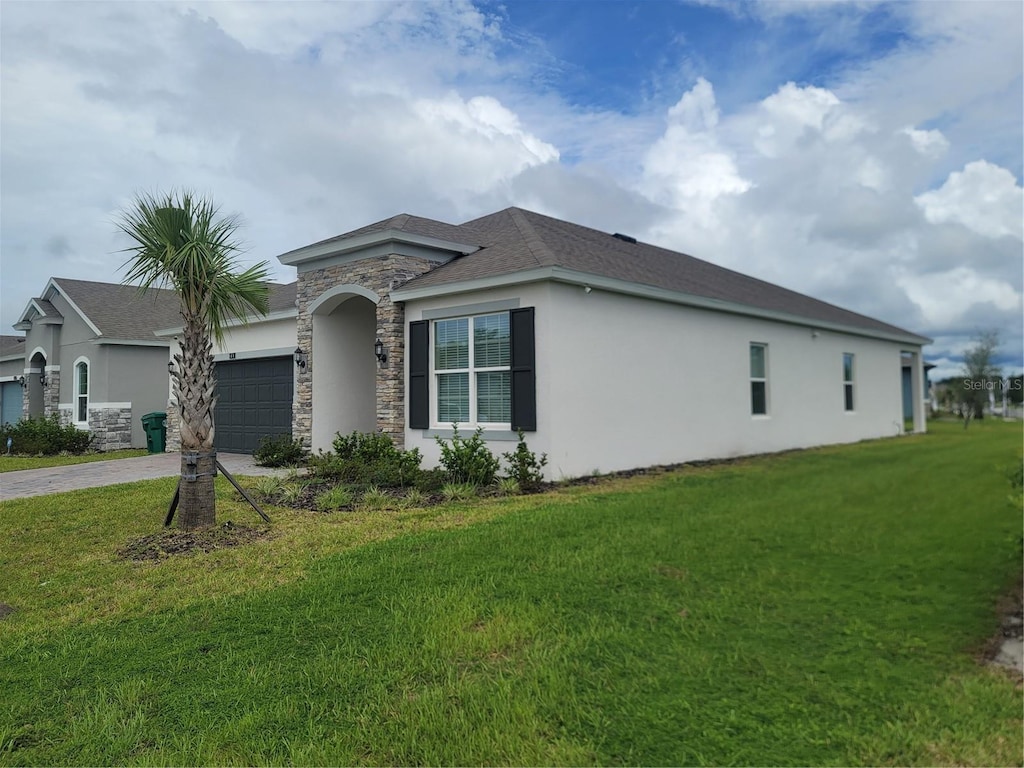 view of side of property featuring a garage and a yard