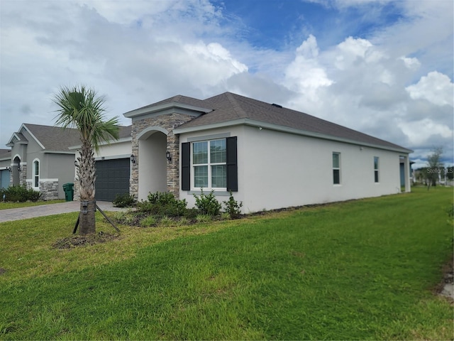 view of side of property featuring a garage and a yard