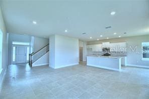 kitchen with a kitchen island with sink and white cabinets