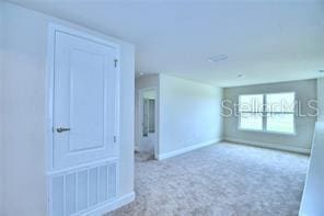 unfurnished room featuring light carpet