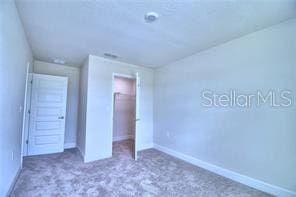 unfurnished bedroom featuring carpet flooring and a closet