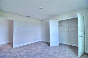 unfurnished bedroom with a closet and carpet flooring