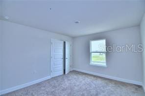 unfurnished room featuring light colored carpet