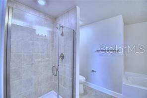 bathroom featuring toilet and shower with separate bathtub