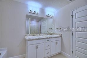 bathroom with vanity and a tub