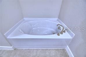 bathroom featuring tile patterned flooring and a bath