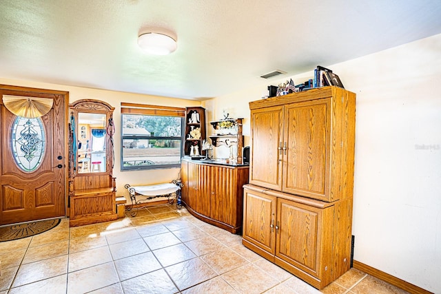 entryway featuring a textured ceiling and light tile patterned flooring