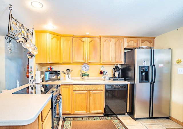 kitchen with black appliances, sink, and light tile patterned flooring