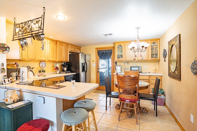 kitchen with hanging light fixtures, kitchen peninsula, an inviting chandelier, and stainless steel refrigerator with ice dispenser