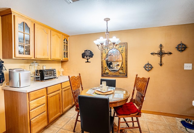 dining area with light tile patterned floors and a chandelier