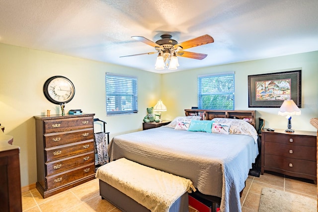 tiled bedroom with a textured ceiling and ceiling fan