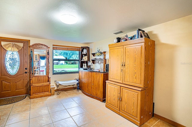 tiled entryway with a textured ceiling