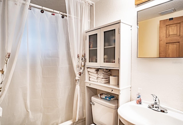 4822 Melody Ln, Lakeland, FL 33805 - full bathroom with a sink, toilet, a textured wall, and shower / bath combination with curtain